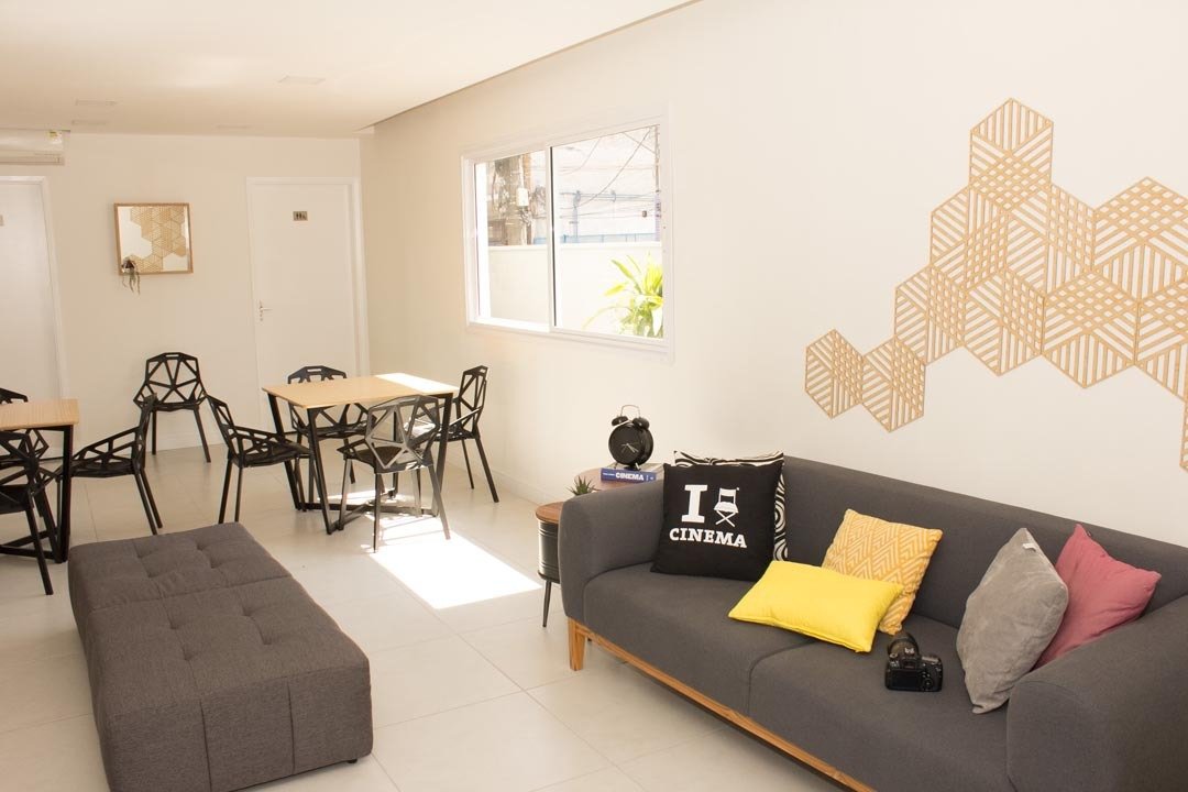 Foto do salão de festas com sofá, mesas e decoração