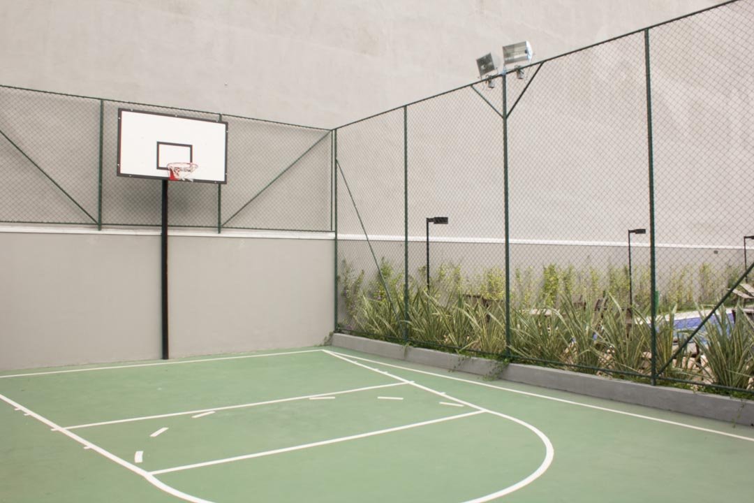 Foto da quadra esportiva com tabela de basquete e alambrado