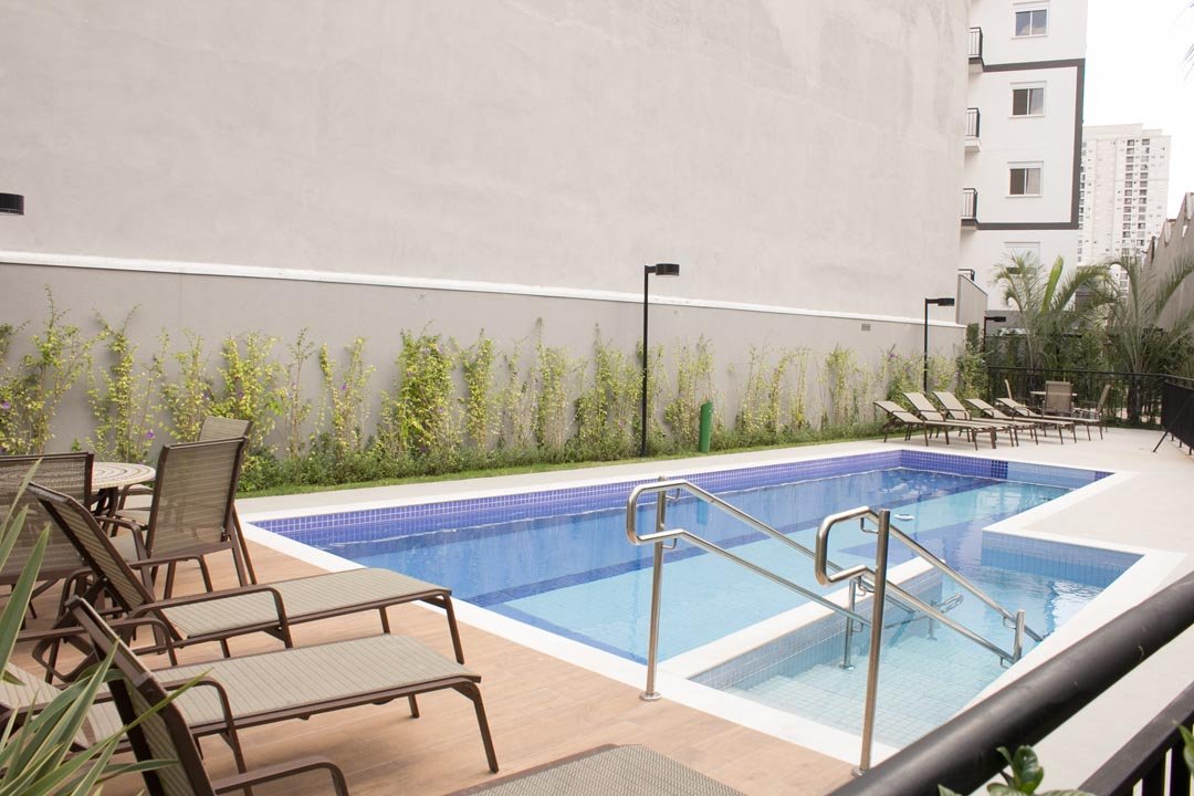 Foto da piscina com deck e espreguiçadeiras na área comum do Br Caetano, depois da entrega