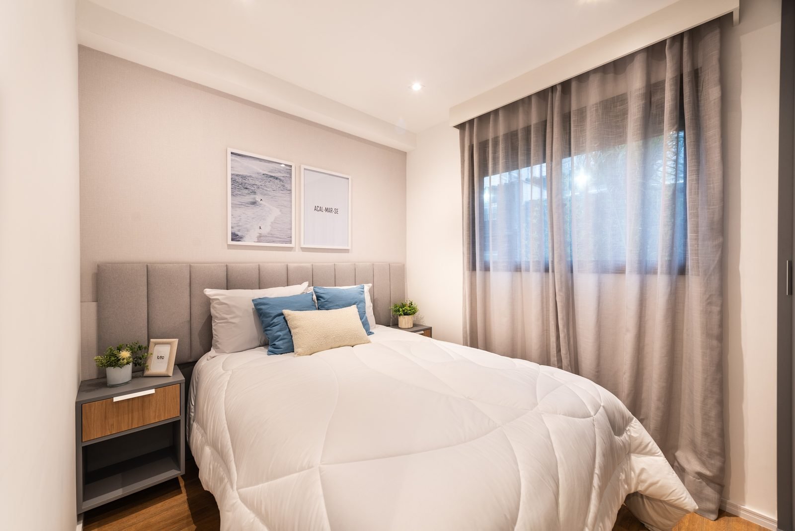 Foto do decorado de 1 dormitório: quarto de casal com cabeceira estofada e cortinas